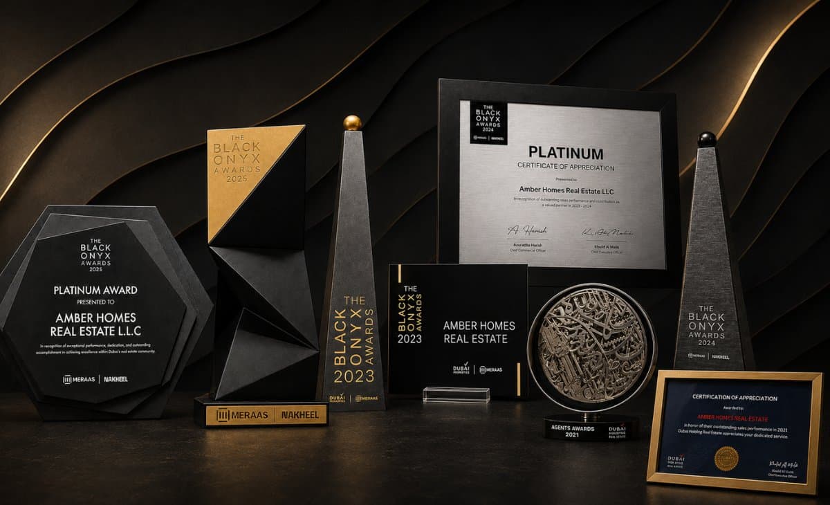 Amber Homes Real Estate's Platinum Agency awards collection — Black Onyx Awards trophies and Platinum certificates from Meraas, Nakheel, Dubai Properties and Dubai Holding, 2021 to 2025